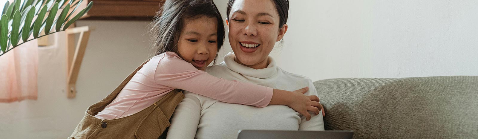A mom and daughter in front of a laptop computer