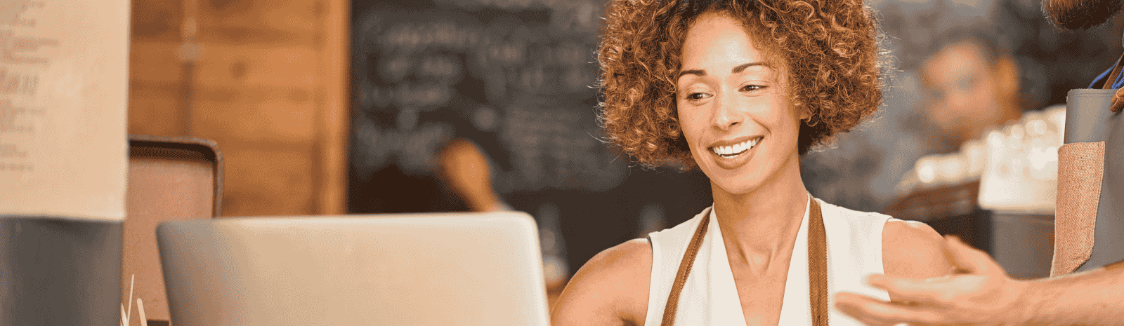 A business owner smiling while looking at her laptop.