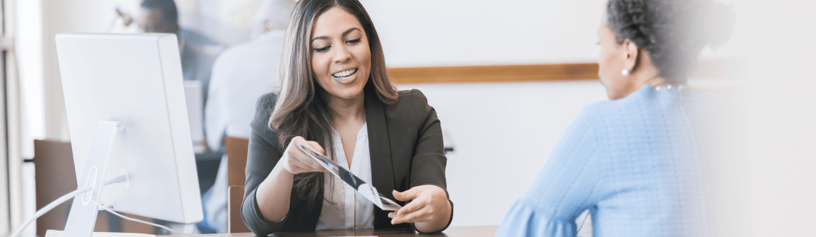 A mid adult female loan officer helps the mature adult customer select from various loan options