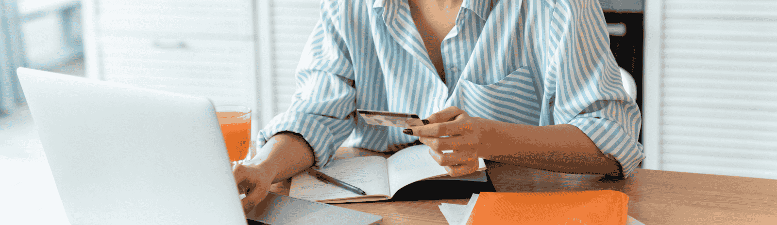 A woman using her laptop computer and holding credit card.